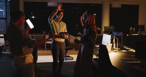 Diverse Business Team Celebrating Success in Night Office