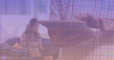 Business professional analyzing stock data on tablet