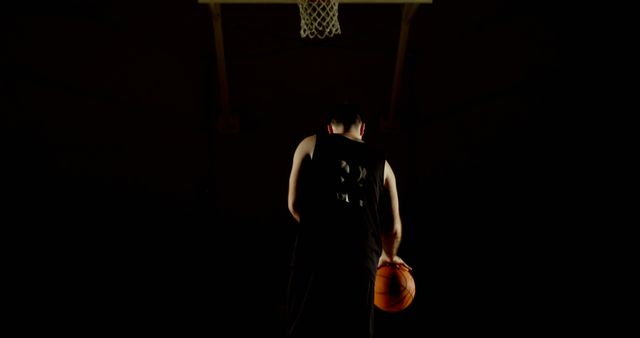 Basketball player alone staring at hoop in darkness before making shot - Download Free Stock Images Pikwizard.com