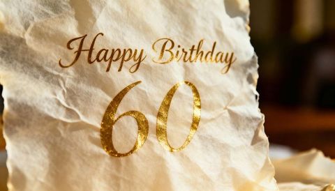 Crumpled parchment featuring gold foil happy birthday 60 with warm bokeh lighting