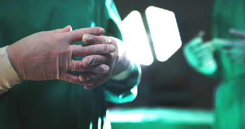 Skillful Surgeons Preparing for Operation in Sterile Environment