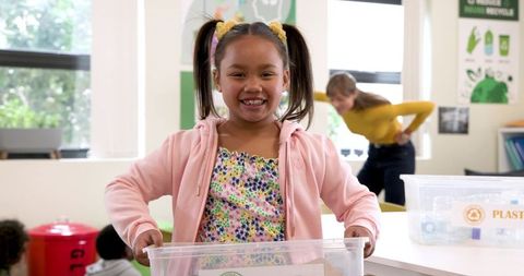 Children recycling in classroom to promote sustainability and teamwork