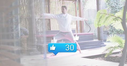 Man practicing outdoor yoga on deck balancing on pink mat with social likes notification