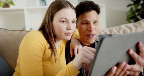 Happy Couple Using Tablet Together On Sofa
