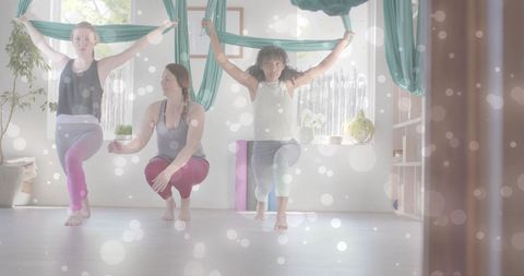 Women Enjoying Aerial Yoga with Illuminating Light Spots