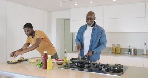 Father and Son Cooking Together in Modern White Kitchen