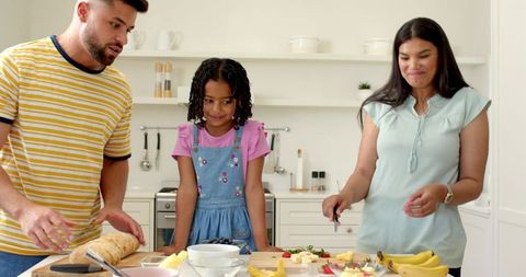Cheerful Family Joyfully Preparing Breakfast Together in Bright Kitchen