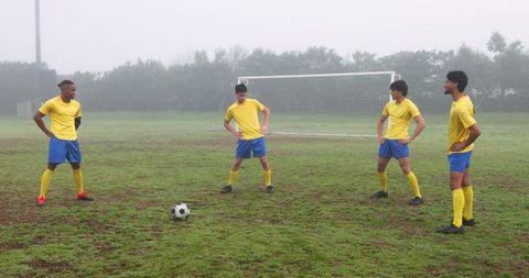 Team strategy session on foggy soccer field