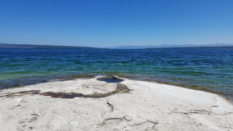Serene Lakeside View with White Rocks and Blue Sky