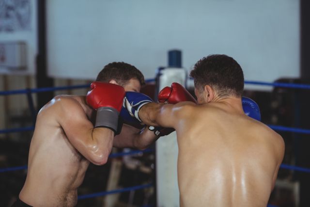 Boxers fighting in boxing ring at arena