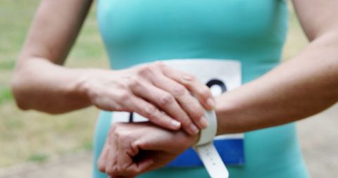 Woman tracking fitness with modern smartwatch in outdoor setting