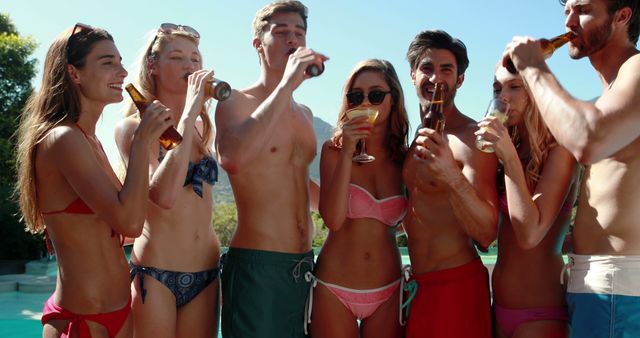 Group of young friends having fun at a pool party on a sunny day. They are drinking beverages and enjoying their time together. This image is perfect for summer lifestyle blogs, party invitations, vacation promotions, or advertisements for swimwear brands.