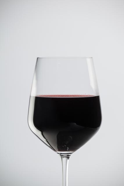 Glass of red wine against white background