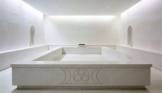 Minimalist marble plunge pool with carved motif and symmetrical spa interior