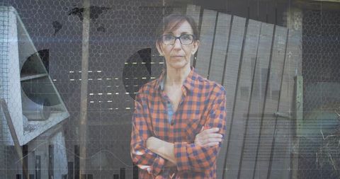 Confident Woman Stands Behind Barn's Wire Mesh Barrier