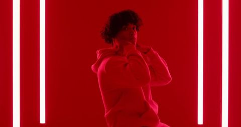 Model Wearing Hoodie in Monochrome Red Room with LED Lights