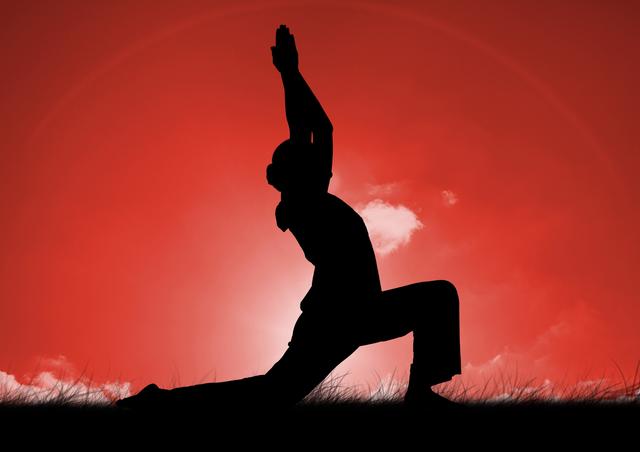 Silhouette of a woman performing a yoga pose on grass with a vibrant red sky in the background. Useful for wellness, fitness, meditation, and outdoor activity themes. Ideal for promoting yoga classes, mindfulness programs, or health retreats.