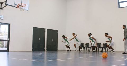 Basketball team agility drill in indoor gymnasium