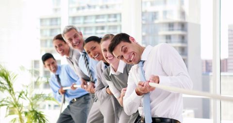 Diverse Business Team Enjoying Tug-of-War Challenge at Office