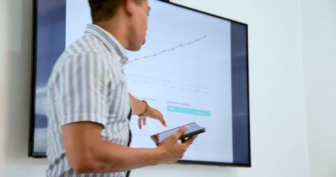 Businessman Presenting Data on Digital Tablet in Modern Office