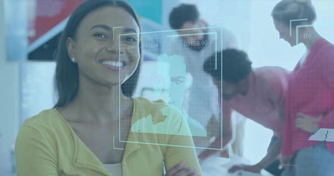 Smiling businesswoman with holographic interface in modern open-plan office team meeting