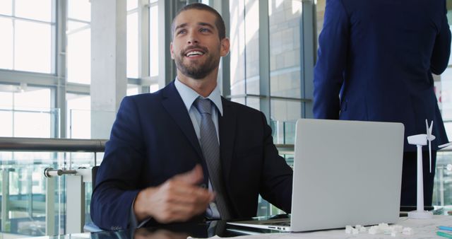 Businessman in Suit Working on Laptop, Modern Office, Positive Expression - Download Free Stock Images Pikwizard.com