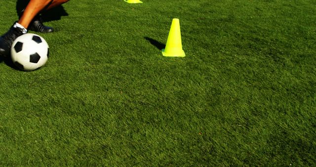 Soccer player practicing in a field, with copy space. Drills with cones are essential for agility and speed training outdoors.