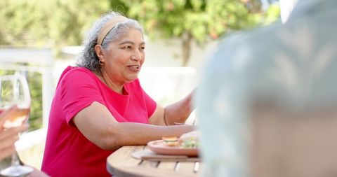 Senior Mixed Race Woman Enjoying Outdoor Meal with Friends - Download Free Stock Images Pikwizard.com