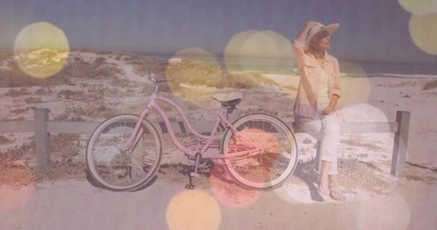 Woman relaxing at coastal path with vintage pink bicycle
