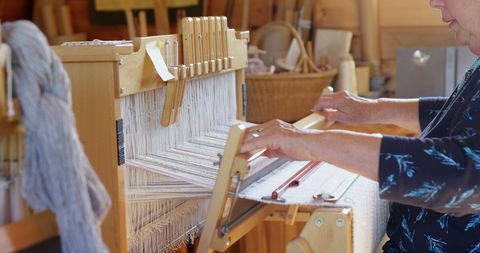 Senior Woman Weaving Cloth on Handloom in Artisan Workshop