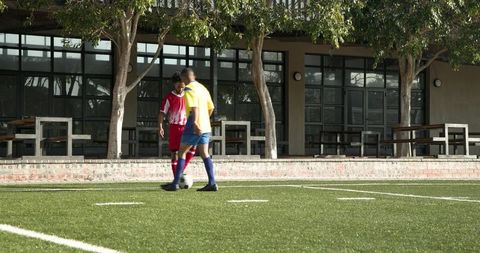 Teen Soccer Players Practicing on School Field Focusing on Team Strategy