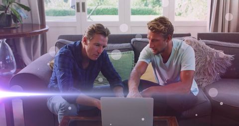 Father and Son Using Laptop with Digital Overlay Effect