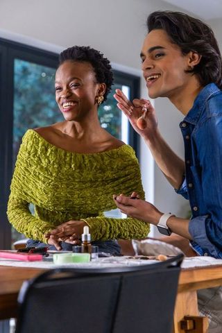 Makeup artist applying foundation during relaxed beauty consultation with smiling client