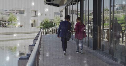 Colleagues Walking Along Waterfront Office Building