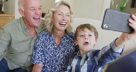 Happy Grandparents with Grandson Taking Selfie at Home