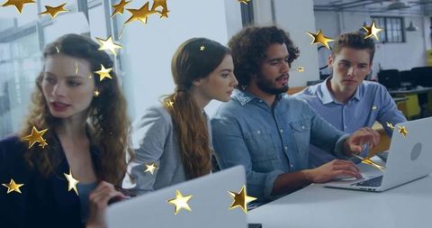 Team Discussion in Modern Office with Laptops and Gold Stars