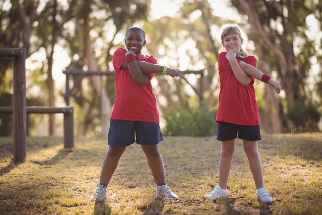 Portrait of happy kids performing stretching exercise during obstacle course - Download Free Stock Photos Pikwizard.com