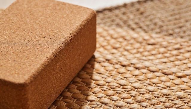 Cork yoga block resting on woven jute mat closeup natural fiber texture earthy copy space