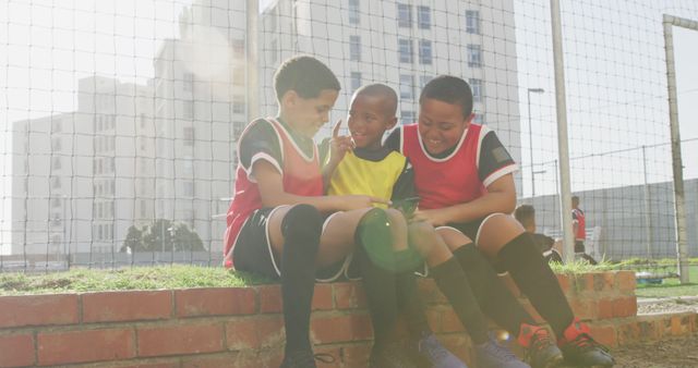 Young Soccer Players Smiling and Sitting During Break Outdoors - Download Free Stock Images Pikwizard.com