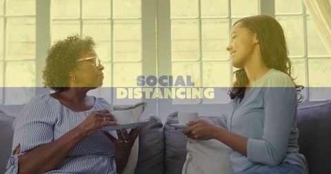 Two Women Social Distancing Over Tea During Pandemic