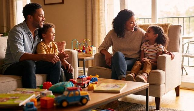 Family enjoying playful afternoon with toy cars and building blocks in cozy living room