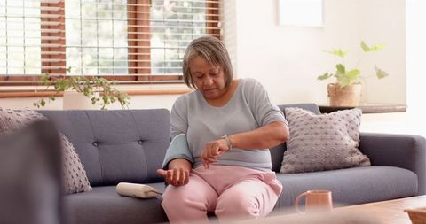 Senior woman monitoring blood pressure at home for health awareness