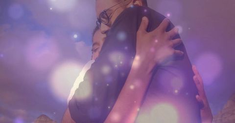 Couple Embracing with Magical Bokeh in Mountainous Setting