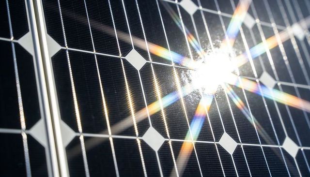 Sunlight Glinting on Monocrystalline Solar Panel with Rainbow Starburst Flare and Glossy Reflection