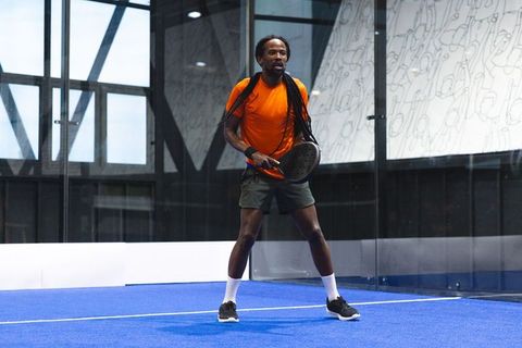 Focused Athlete Playing Padel in Modern Glass Arena