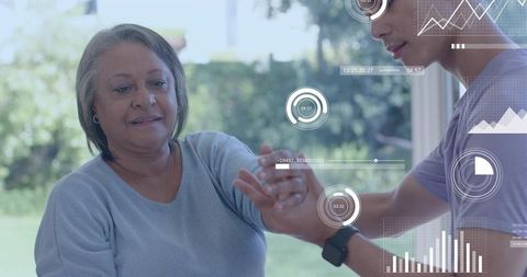Caregiver assisting senior woman with arm rehabilitation using smartwatch data overlays