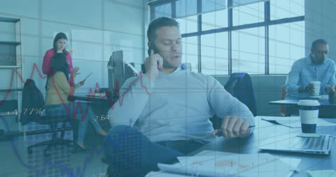 Businessman Analyzing Financial Data in Modern Office with Team