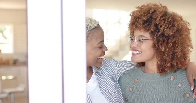 Smiling friends embracing with natural hairstyles indoors - Download Free Stock Images Pikwizard.com