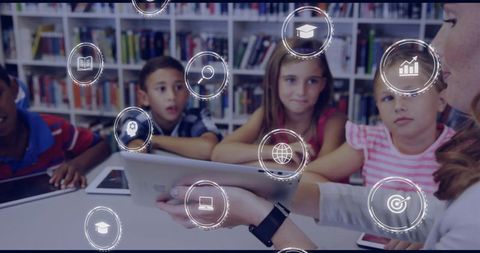 Teacher showing tablet to elementary students in library digital learning icons floating