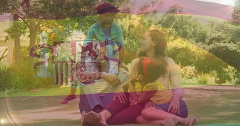 Family relaxing on sunny park lawn with children playing and sharing moments